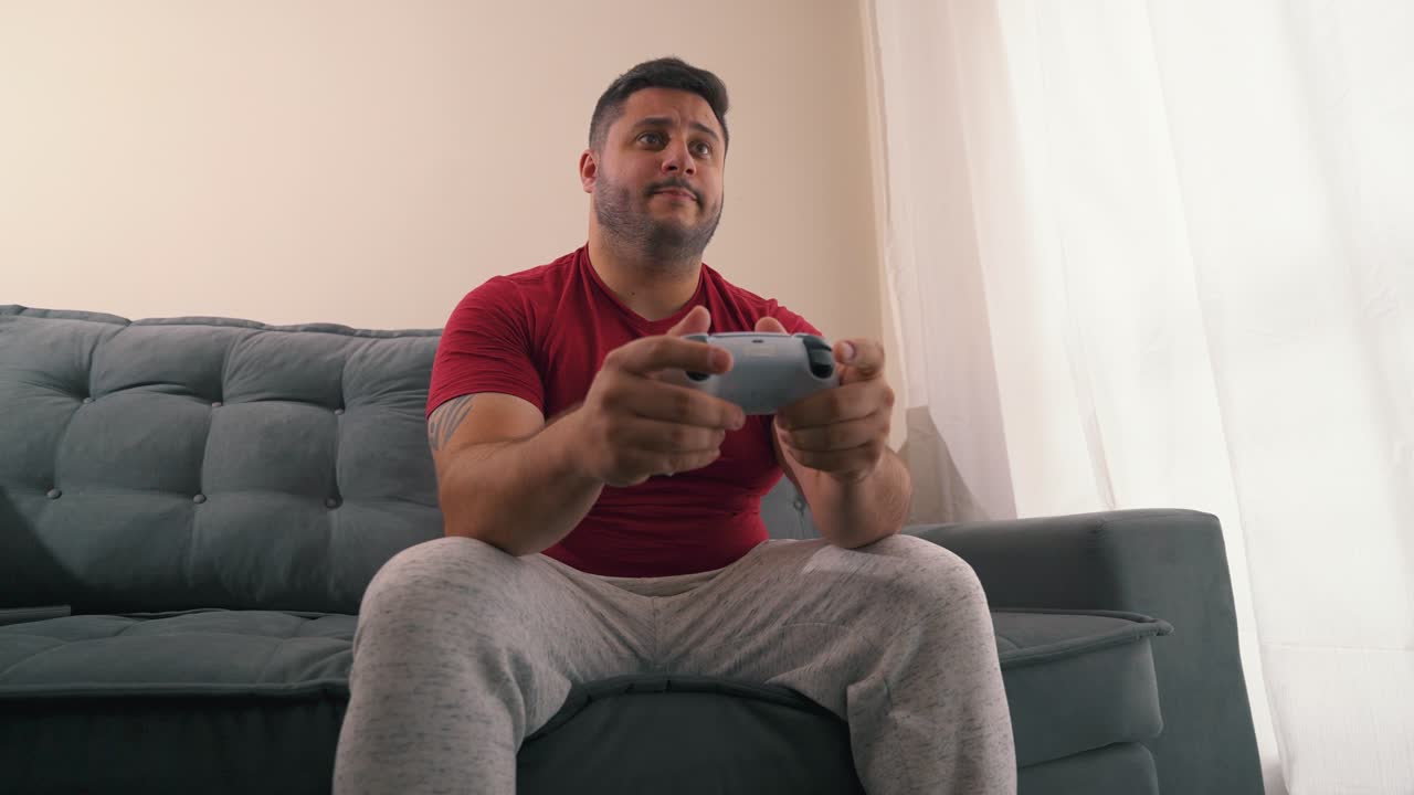 hombre confiado celebrando logros jugando videojuegos con controlador de consola en sus manos