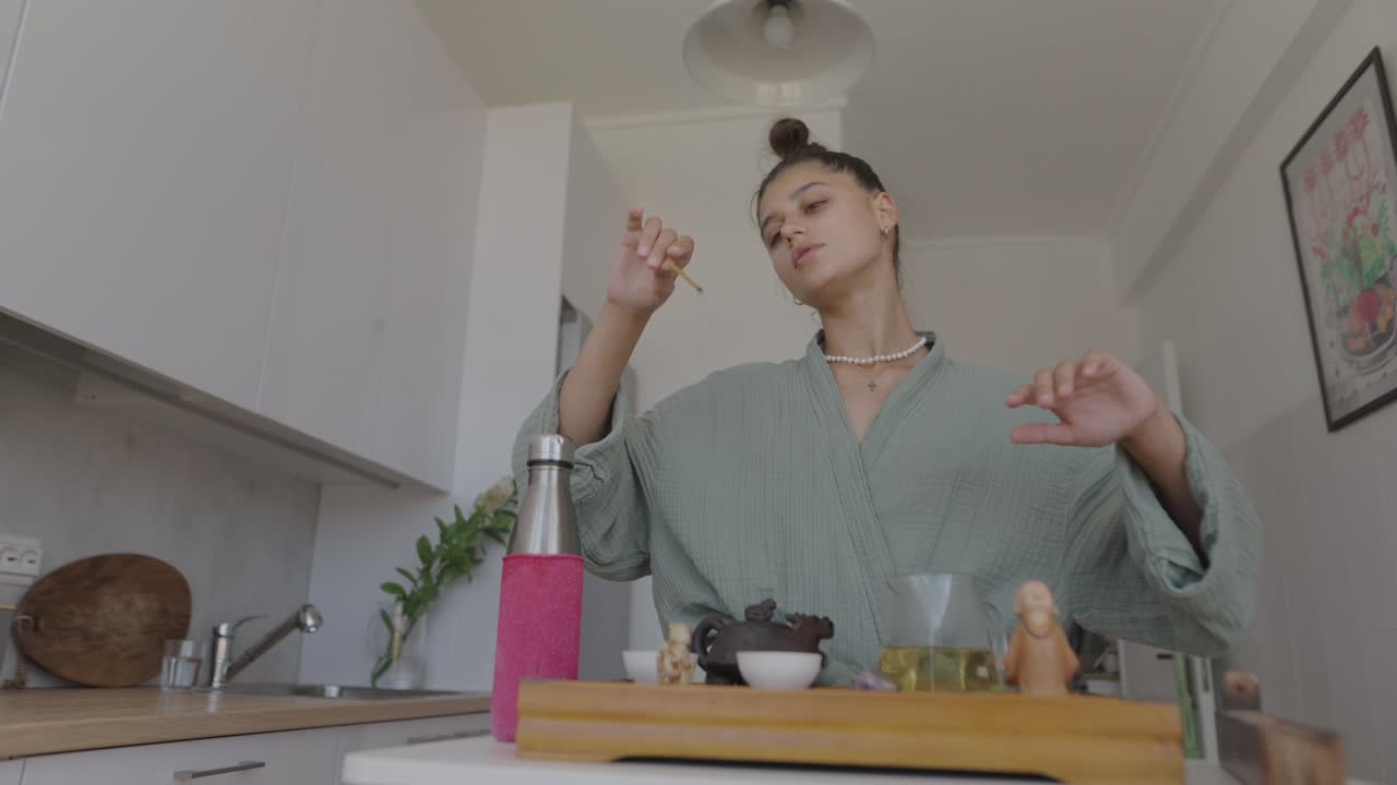 Woman performing a tea ceremony with incense