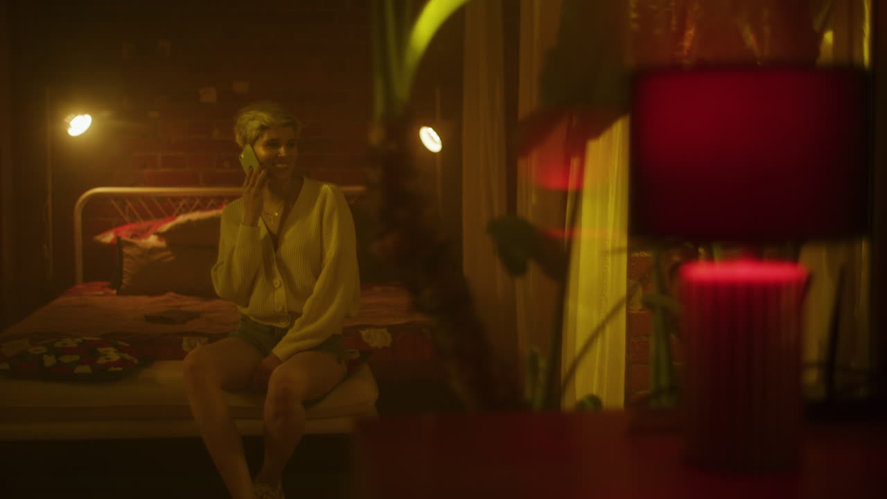 Woman Talking on Phone in a Cozy Bedroom at Night