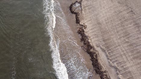 cold north sea waves splashing onto freshly raked beach in england