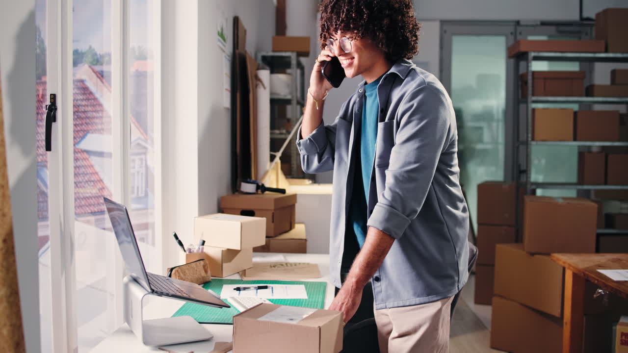 Happy Young Man on Phone Call While Working in Small Business Office