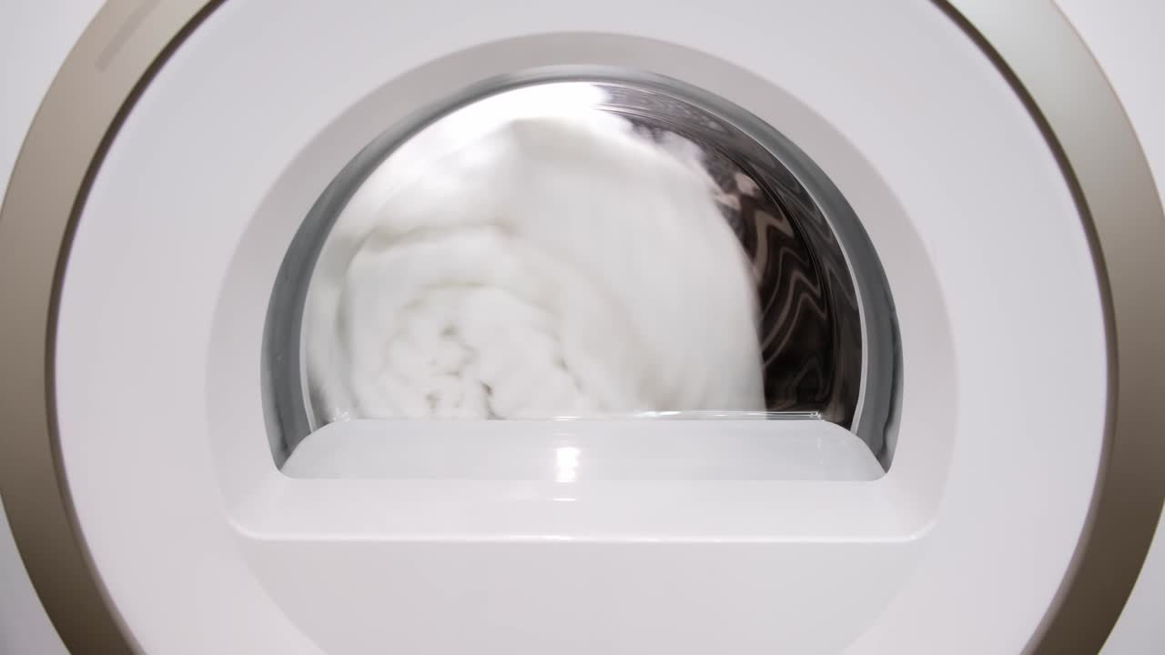 4k 덤블 건조기는 시작됩니다. 색 세탁기의 건조 주기 클로즈업. 드럼 회전. 야간 모드. 백라이트. 신선하고 건조한 옷. 기술 진보. 운동. 스핀. 세탁기. 숙제 루틴 보조.