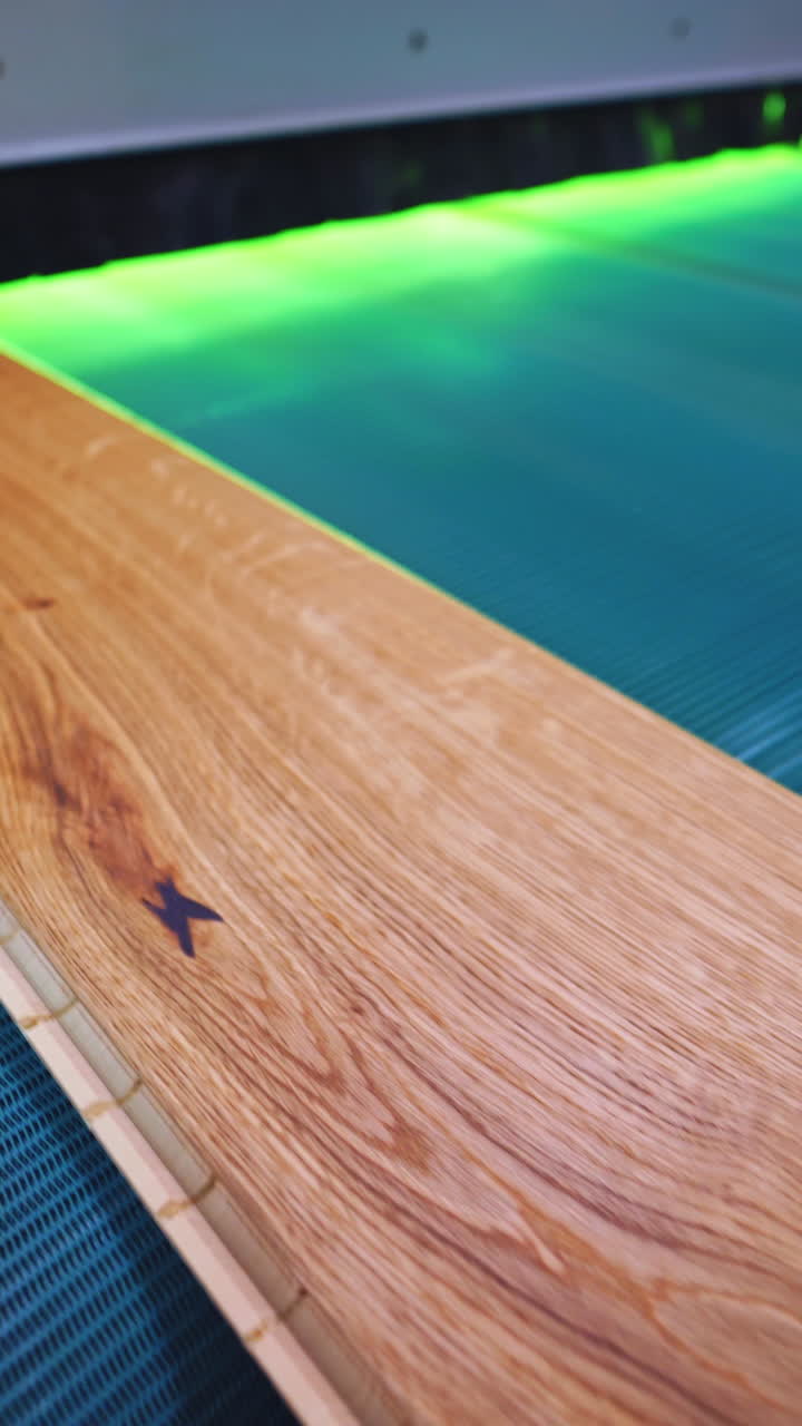 Parquet factory. Wooden laminate board moving on a conveyor line inside the modern industrial plant. Furniture production. Vertical video