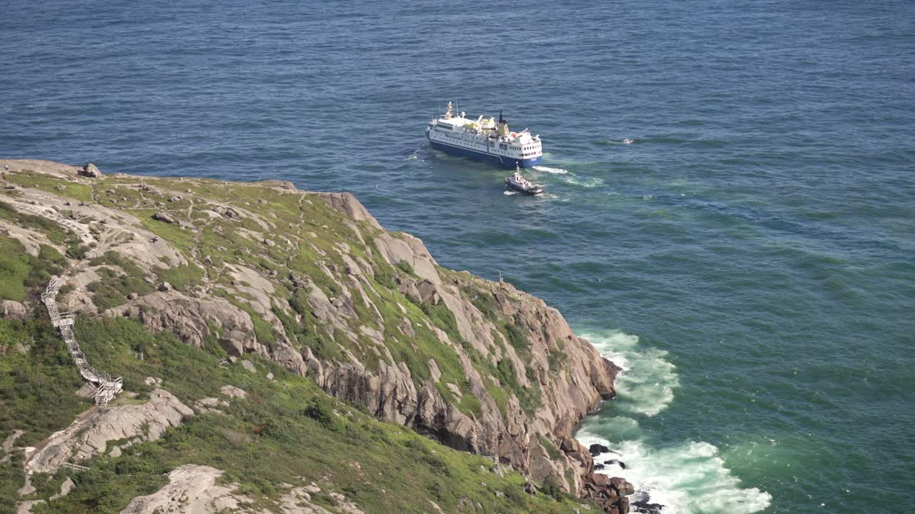 un crucero y un remolcador salen del puerto de san juan en terranova, canadá.