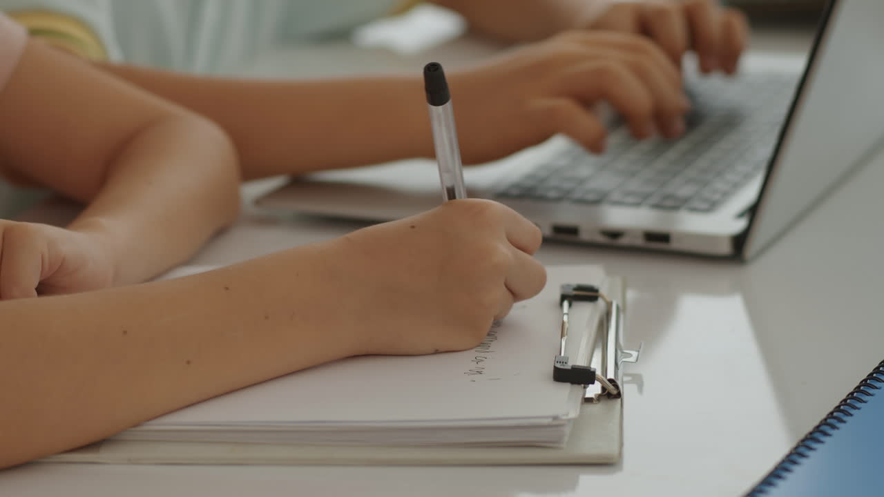 Unrecognizable Schoolboy Doing Test on Paper during Computer Class