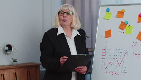 mujer ejecutiva de negocios, entrenadora, líder, oradora de la conferencia, explica la estrategia del proyecto en la pizarra de la oficina.