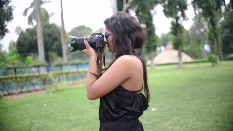 a tourist asian girl takes photograph with a dslr camera at a nature park