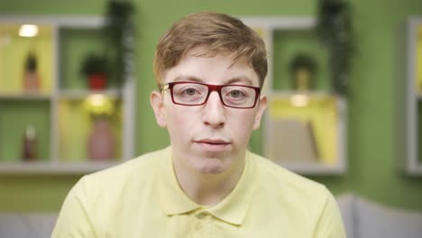 young man looking at camera at home babbling.