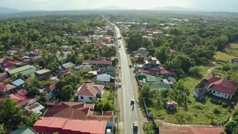 cloudy landscape aerial of philippine road traffic through tropical town 4k