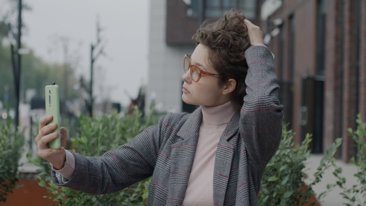 젊은 여성이 야외에서 셀피를 찍고 있다