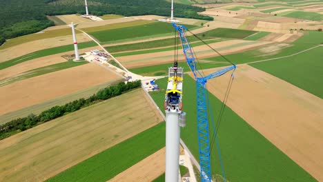 wind turbine during construction in agricultural fields - drone shot