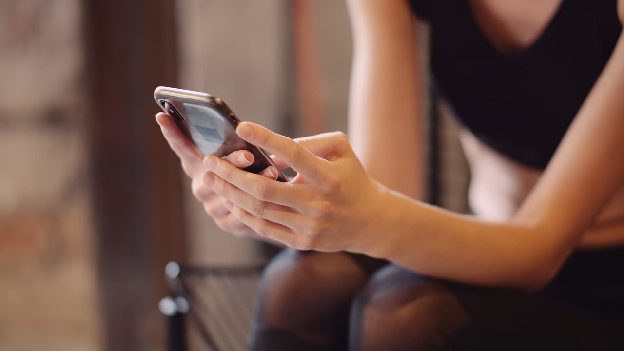 Mezzo busto di donna che invia messaggi tramite cellulare in un centro benessere