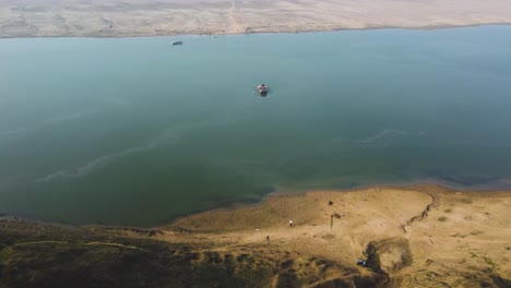 Aerial-Drone-shot-of-a-traditional-wood-boat-in-blue-Chambal-River-in-Morena-Dholpur-of-Madhya-Pradesh-Rajasthan-in-India