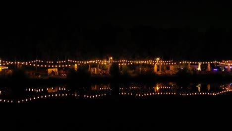 3 ponds in katowice city - lakeside bar with light reflections in water during midnight - aerial view 4k