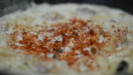 Close-up-shot-of-cooking-creamy-white-sauce-for-pasta-in-a-pan,-sauce-boiling-in-a-pan