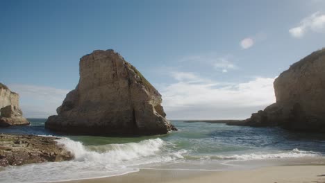 establishing shot of waves gently breaking on beach at shark fin cove