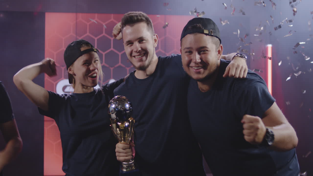 Gaming Tournament Team Celebrating their Victory Medium Shot of a Gaming Tournament Team Holding their Prize while Celebrating their Victory