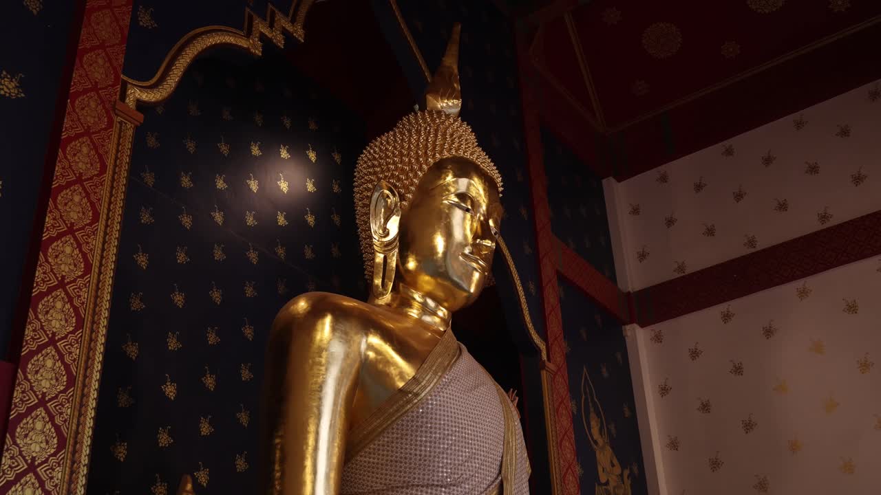 mirando una estatua de oro de buda en un templo en la antigua ciudad de rattanakosin de bangkok, tailandia