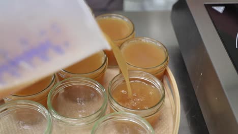 pouring apple jam into jars - high angle, orbiting shot