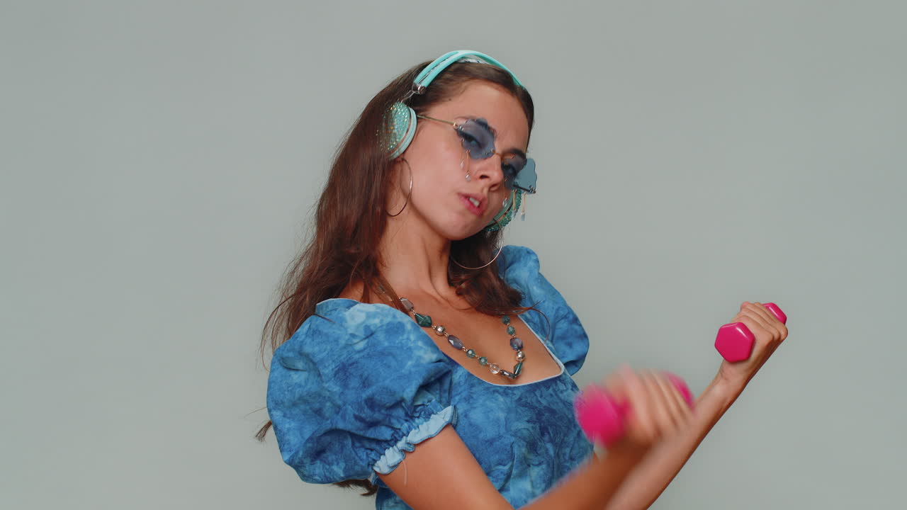 mujer haciendo ejercicio, bombeando los músculos de los brazos levantando pesas rosas, practicando pilates, atención médica