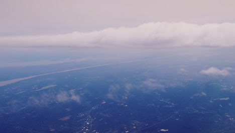 View-From-The-Plane-Window-To-The-Ground-Far-Below-And-Clouds