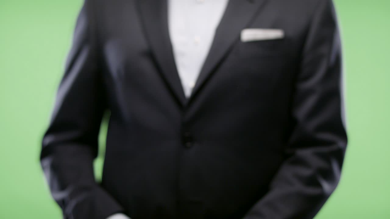 Businessman wink & and gun on green screen.