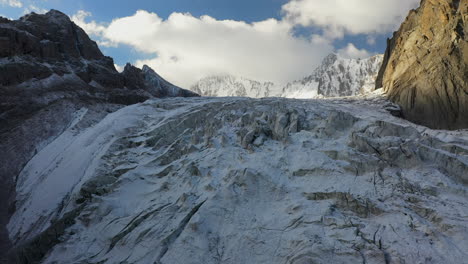 reveladora toma cinematográfica de drones de una colina hacia abajo en una abertura a través del glaciar ak-sai en kirguistán