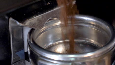 Coffee-being-finely-ground-into-espresso-machine