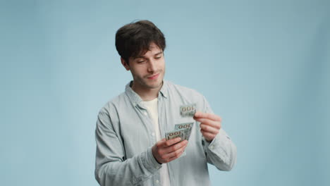 man looking at stacks of money