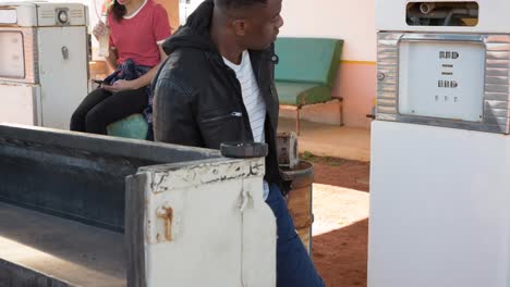 Diverse-man-and-woman-using-fuel-pump-filling-up-truck-at-petrol-station