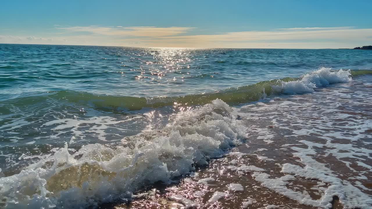 Onde che si infrangono creando schiuma bianca e riflessi del sole sulla costa bagnata, mareggiate in arrivo dall'orizzonte