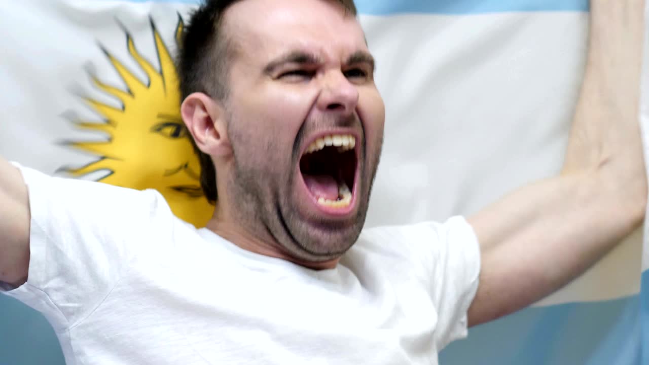 fanático argentino celebrando mientras sostiene la bandera de argentina en cámara lenta, 4k, de alta calidad
