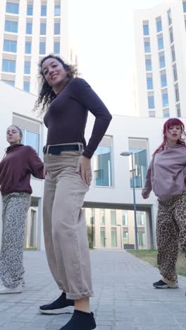 group of young women dancing outside a modern building