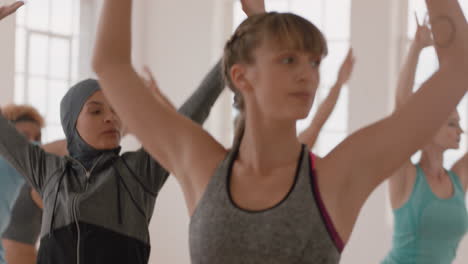 yoga-class-of-young-multi-ethnic-people-practicing-warrior-pose-enjoying-healthy-lifestyle-fitness-instructor-guiding-meditation-exercise-in-studio