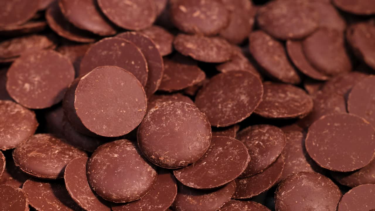 우유 초콜릿 조각이 떨어지고 쌓여 있습니다.