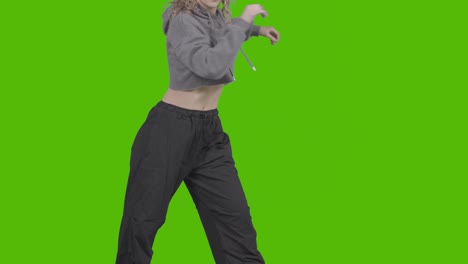 close up studio shot of young woman having fun dancing against green screen