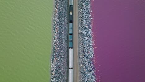 aerial - railway, purple, green water in lucin cutoff, great salt lake, utah, top down