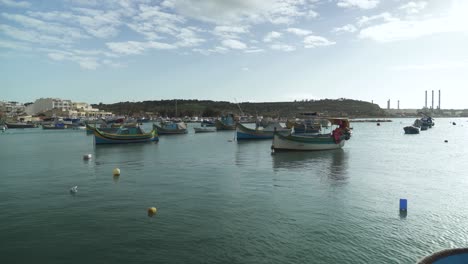 un montón de hermosos barcos de madera flotando en la bahía de marsaxlokk en el día de invierno en malta