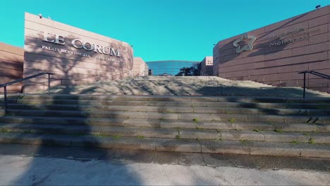 toma cinematográfica fpv de árboles en flor y la entrada a le corum en montpellier