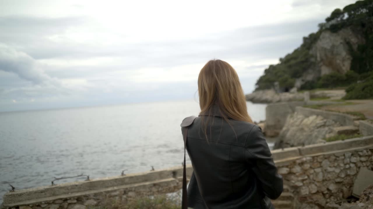 아름다운 해안 풍경의 사진을 찍는 여자.