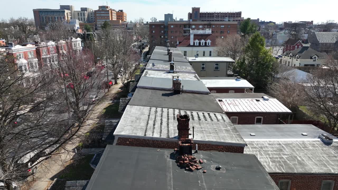 drone ascendente disparado en la ciudad estadounidense que muestra viejas chimeneas en el techo de las casas en la ciudad durante el día soleado