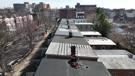 Ascending-drone-shot-in-american-city-showing-old-chimneys-in-roof-of-houses-in-town-during-sunny-day