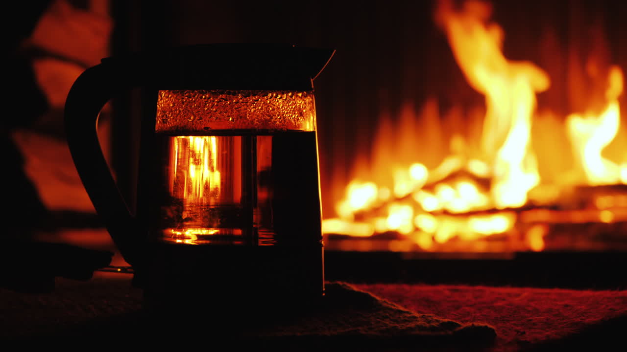 el agua hierve en un hervidor eléctrico retroiluminado un fuego en el fondo arde en el fondo