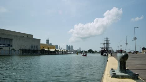 cartagena quay with motorboat, galleon, distant skyscrapers