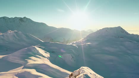 Antenne:-Winterberglandschaft,-Sonne-Scheint-über-Berggipfel