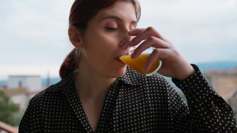 italian woman drinks orange carrot juice to take vitamins in the morning