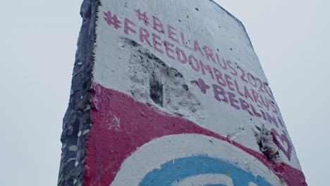 Closeup-of-Berlin-wall-with-graffiti-about-Belarus-freedom,-circle-pan,-day