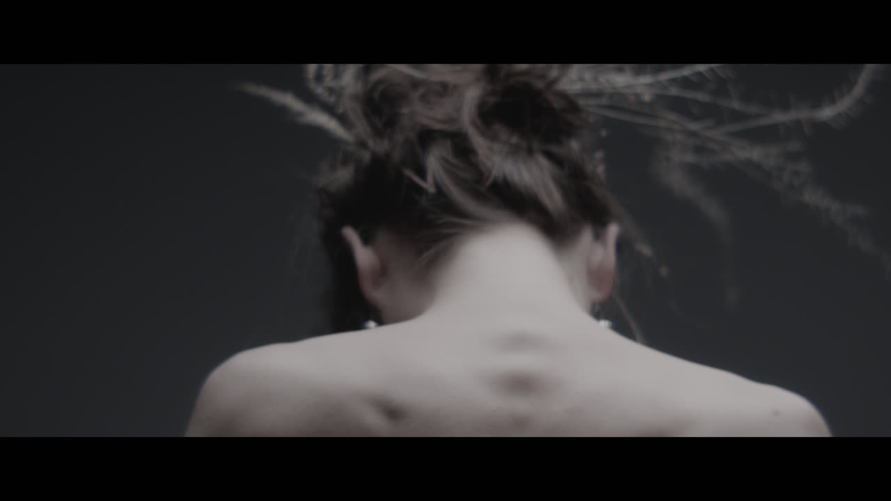 A woman dressed as mother nature moves slowly in a dance-like motion