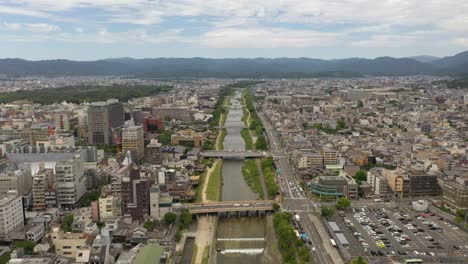 Aerial-of-Kyoto-with-Kamo-river,-temples,-and-city-skyline-in-Kyoto,-Japan