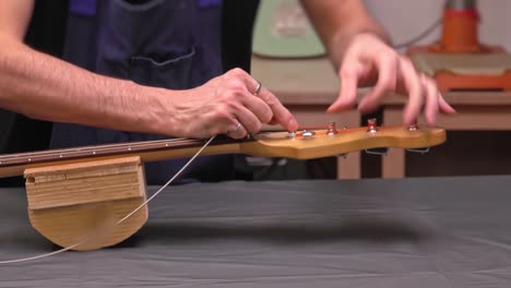 putting new guitar string through the tuning machine post